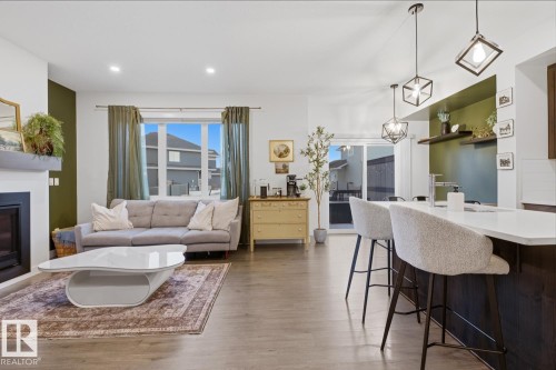 Open concept living area featuring wood-look flooring, a fireplace with a mantel, and recessed lighting - 405 Genesis Court, Stony Plain, AB - Indoor With Fireplace