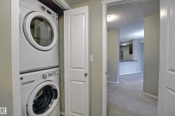 Dedicated laundry closet featuring a stacked white washer and dryer unit - 
