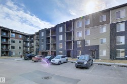 Modern multi-story building featuring varied facade materials including horizontal siding and dark stone-look finishes - 