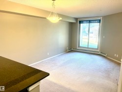 Spacious living area featuring neutral-toned walls and light-colored carpeting - 
