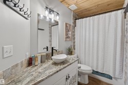 Bathroom featuring a granite countertop, vessel sink, and matte black faucet - 