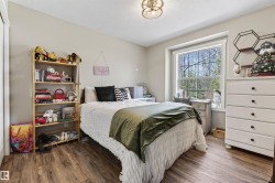 Spacious room featuring wood-finish flooring, light neutral wall paint, and a large window with white trim - 