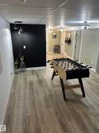 Spacious room with wood-finish flooring, a drop-tile ceiling, and recessed lighting - 