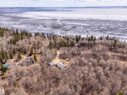 Expansive treed property with multiple structures situated on a large body of water - 