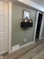 Light green painted wall featuring white baseboards, a white door frame, and a white paneled door - 