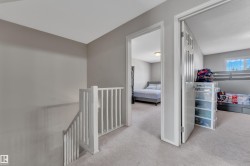Upper-level hallway with light gray walls and plush carpet flooring - 