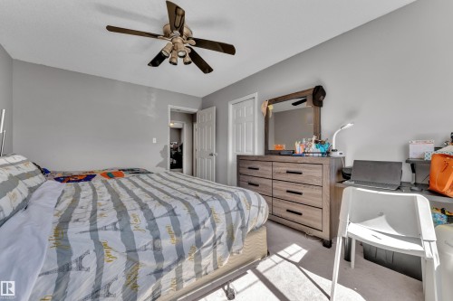 Bedroom featuring light gray wall paint, a ceiling fan with integrated lighting, and neutral-toned carpeting - 64 4350 23 Street, Edmonton, AB - Indoor Photo Showing Bedroom