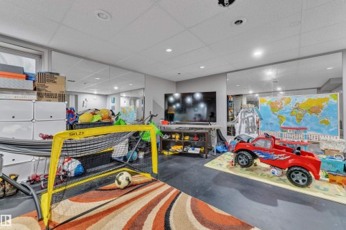Finished basement space featuring recessed lighting, a drop ceiling, and full-wall mirrors - 64 4350 23 Street, Edmonton, AB - Indoor Photo Showing Garage