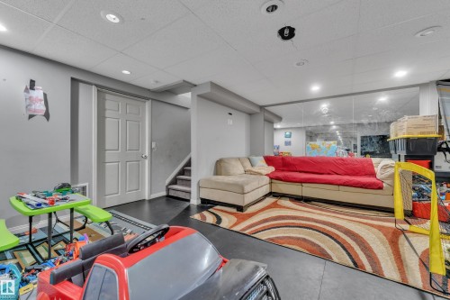 Finished lower level featuring recessed lighting, dark wood-finish flooring, a white paneled door, and carpeted stairs - 64 4350 23 Street, Edmonton, AB - Indoor