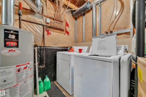 Utility area featuring a water heater and laundry appliances - 64 4350 23 Street, Edmonton, AB - Indoor Photo Showing Laundry Room