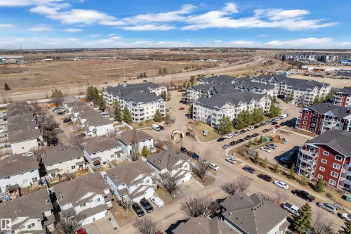 Aerial depiction of a residential community featuring townhomes and multi-story apartment buildings - 64 4350 23 Street, Edmonton, AB - Outdoor With View