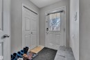 Front entry featuring a paneled door with glass insert, a built-in closet with bi-fold doors, and light gray wall paint - 64 4350 23 Street, Edmonton, AB  - Indoor Photo Showing Other Room 
