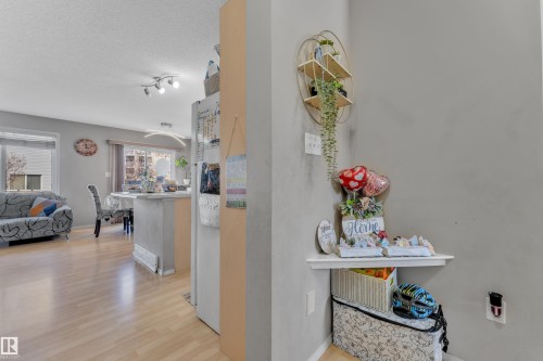 Open-concept living space featuring wood-finish flooring, recessed lighting, and ample natural light from multiple windows - 64 4350 23 Street, Edmonton, AB - Indoor