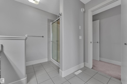 Shower enclosure featuring a glass door and tiled surround - 3363 13 Avenue, Edmonton, AB - Indoor Photo Showing Other Room