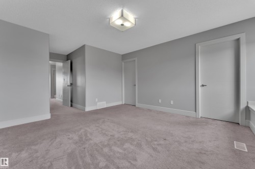 Room featuring light gray walls, plush carpet flooring, a contemporary flush mount ceiling light, white trim, and white interior doors - 3363 13 Avenue, Edmonton, AB - Indoor Photo Showing Other Room
