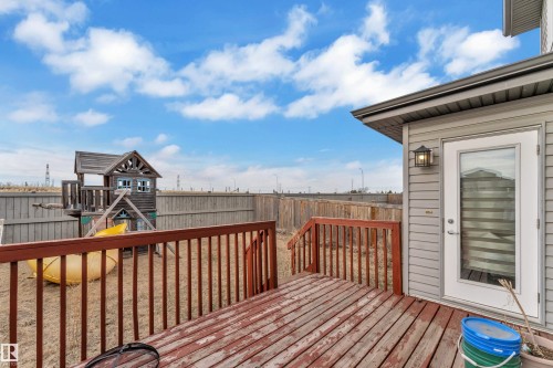 Spacious backyard featuring a wooden deck with railing, a privacy fence, and a walk-out door with glass inserts - 3363 13 Avenue, Edmonton, AB - Outdoor With Deck Patio Veranda With Exterior