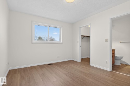 Room featuring wood-finish flooring, white baseboards, and a window with white trim - 8403 190 Street, Edmonton, AB - Indoor Photo Showing Other Room
