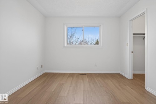 Bright room with wood-finish flooring, crisp white walls, and a large window - 8403 190 Street, Edmonton, AB - Indoor Photo Showing Other Room