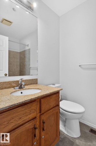 Bathroom vanity featuring a light-toned countertop with an undermount sink and chrome faucet - 8403 190 Street, Edmonton, AB - Indoor Photo Showing Bathroom
