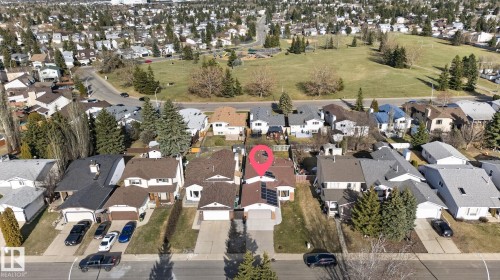 Residential property featuring a brown shingle roof, attached garage, and a paved driveway - 8403 190 Street, Edmonton, AB - Outdoor With View