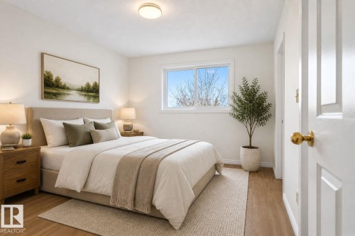 Bedroom featuring wood-finish flooring, a contemporary flush-mount ceiling light, white baseboards, and a window with white trim - 8403 190 Street, Edmonton, AB - Indoor Photo Showing Bedroom