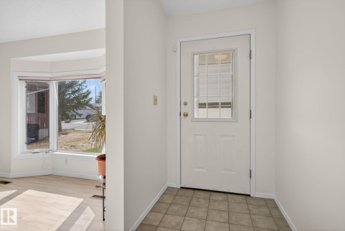 Entryway with tile flooring featuring a white door with frosted glass insert and a bay window - 8403 190 Street, Edmonton, AB - Indoor Photo Showing Other Room