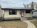 Exterior featuring stucco siding, a black metal roof, and black-trimmed windows - 7550 81 Avenue Nw, Edmonton, AB  - Outdoor 