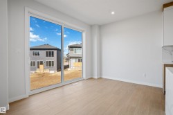 Sliding glass door opening to an exterior space with light wood-finish flooring, white baseboards, and neutral wall tones - 