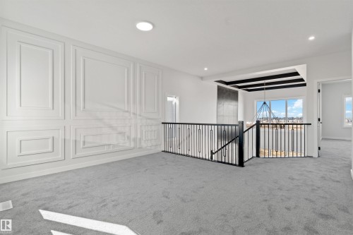White paneled accent wall complemented by light grey carpeting - 1849 Crossbill Loop, Edmonton, AB - Indoor Photo Showing Other Room