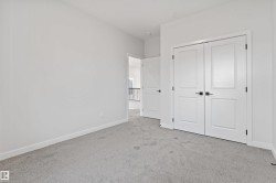 Light gray carpeting complementing white walls, trim, and solid core doors with matte black hardware - 