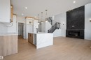 Open-concept living space featuring light wood-finish flooring - 1849 Crossbill Loop, Edmonton, AB  - Indoor With Fireplace 