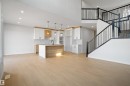 Open-concept living area featuring light wood-finish flooring, recessed lighting, and a modern kitchen - 1849 Crossbill Loop, Edmonton, AB  - Indoor Photo Showing Kitchen 