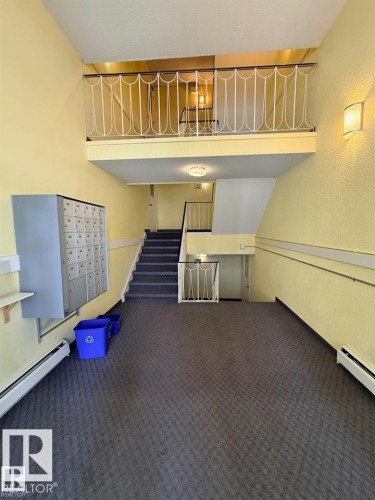 Multi-level interior featuring a carpeted staircase and landing - 106 10725 111 Street, Edmonton, AB - Indoor Photo Showing Other Room