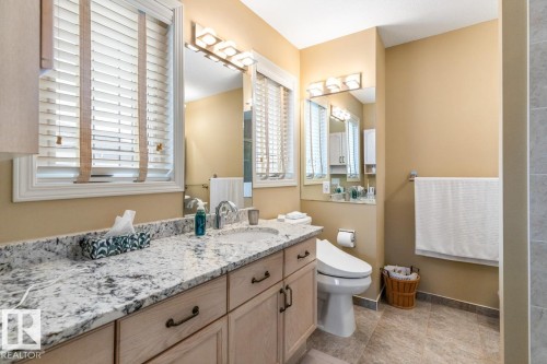 Double vanity with granite-style countertop and integrated sinks - 47 1130 Falconer Road, Edmonton, AB - Indoor Photo Showing Bathroom