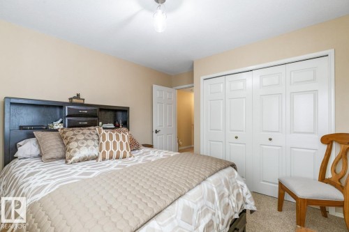 Carpeted room featuring light beige wall paint and a ceiling-mounted light fixture - 47 1130 Falconer Road, Edmonton, AB - Indoor Photo Showing Bedroom