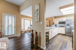 Spacious kitchen with light-toned cabinetry, stainless steel appliances, and a granite-look countertop - 