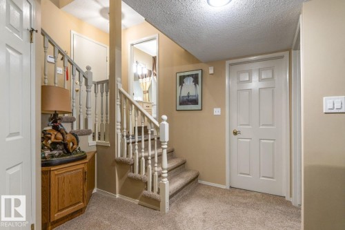 Carpeted staircase with white balusters - 47 1130 Falconer Road, Edmonton, AB - Indoor Photo Showing Other Room