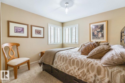 Corner windows featuring white plantation shutters and neutral-toned walls - 47 1130 Falconer Road, Edmonton, AB - Indoor Photo Showing Bedroom