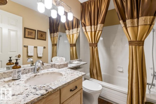 Bathroom featuring a vanity with a light-toned countertop, an undermount sink, and a chrome faucet - 47 1130 Falconer Road, Edmonton, AB - Indoor Photo Showing Bathroom
