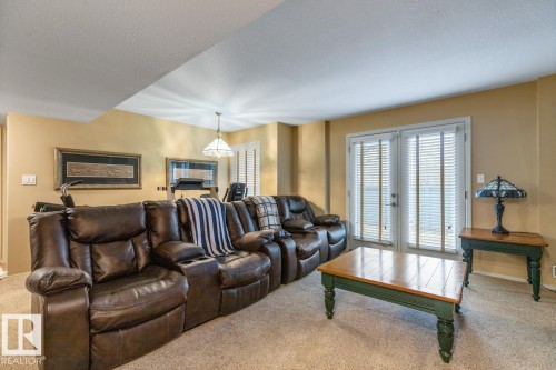 Room featuring wall-to-wall carpeting and a neutral color palette - 47 1130 Falconer Road, Edmonton, AB - Indoor Photo Showing Living Room With Fireplace