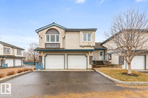 Stucco exterior with blue trim accents and multi-pane windows - 47 1130 Falconer Road, Edmonton, AB - Outdoor With Facade