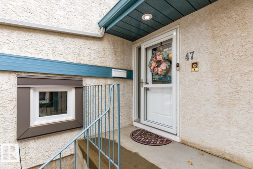Exterior entry featuring stucco finish, a white storm door, and a recessed ceiling light - 47 1130 Falconer Road, Edmonton, AB - Outdoor With Exterior