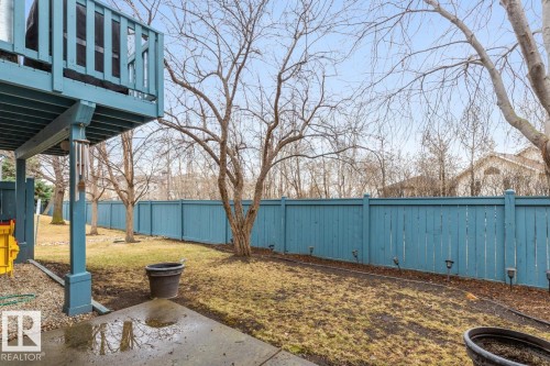 Private backyard featuring a blue privacy fence with ground-level lighting - 47 1130 Falconer Road, Edmonton, AB - Outdoor