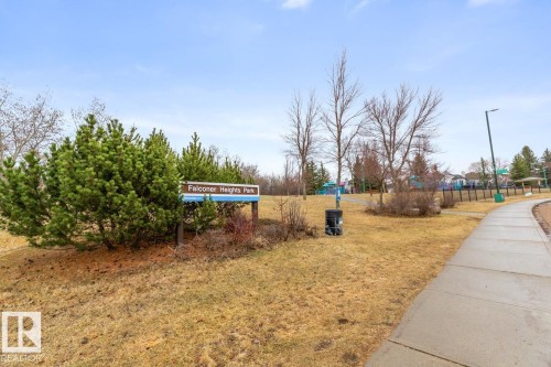 Falconer Heights Park sign surrounded by evergreen shrubs and bare trees - 47 1130 Falconer Road, Edmonton, AB - Outdoor
