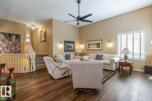 Living area featuring high ceilings, wood-finish flooring, and a ceiling fan - 47 1130 Falconer Road, Edmonton, AB - Indoor Photo Showing Living Room