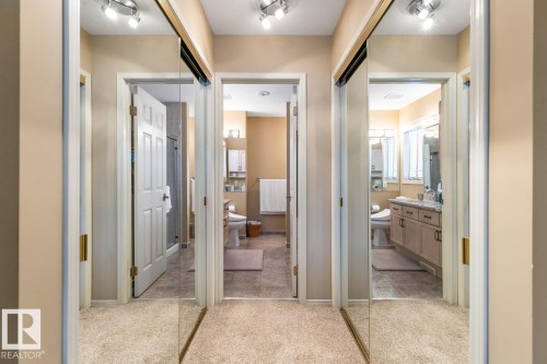 Hallway featuring mirrored sliding closet doors with track lighting - 47 1130 Falconer Road, Edmonton, AB - Indoor Photo Showing Other Room