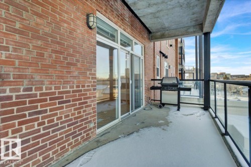 Private balcony featuring a concrete floor and red brick wall - 406 10728 82 Avenue, Edmonton, AB - Outdoor With Balcony With Exterior