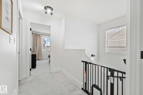 Carpeted upper hallway with white walls and trim - 53 2503 24 Street, Edmonton, AB - Indoor Photo Showing Other Room