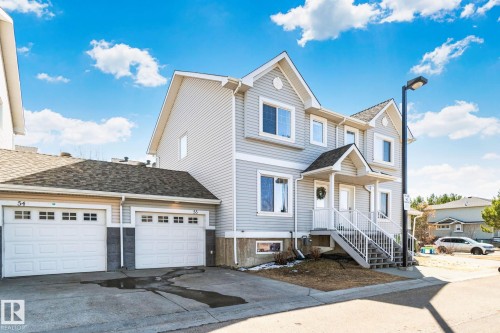 Multi-level residence featuring light-toned siding, white trim, and a covered entry - 53 2503 24 Street, Edmonton, AB - Outdoor With Facade