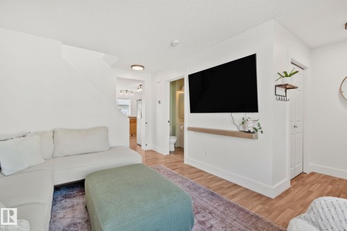 Living area featuring wood-finish flooring, white walls, and a recessed ceiling light - 53 2503 24 Street, Edmonton, AB - Indoor Photo Showing Living Room